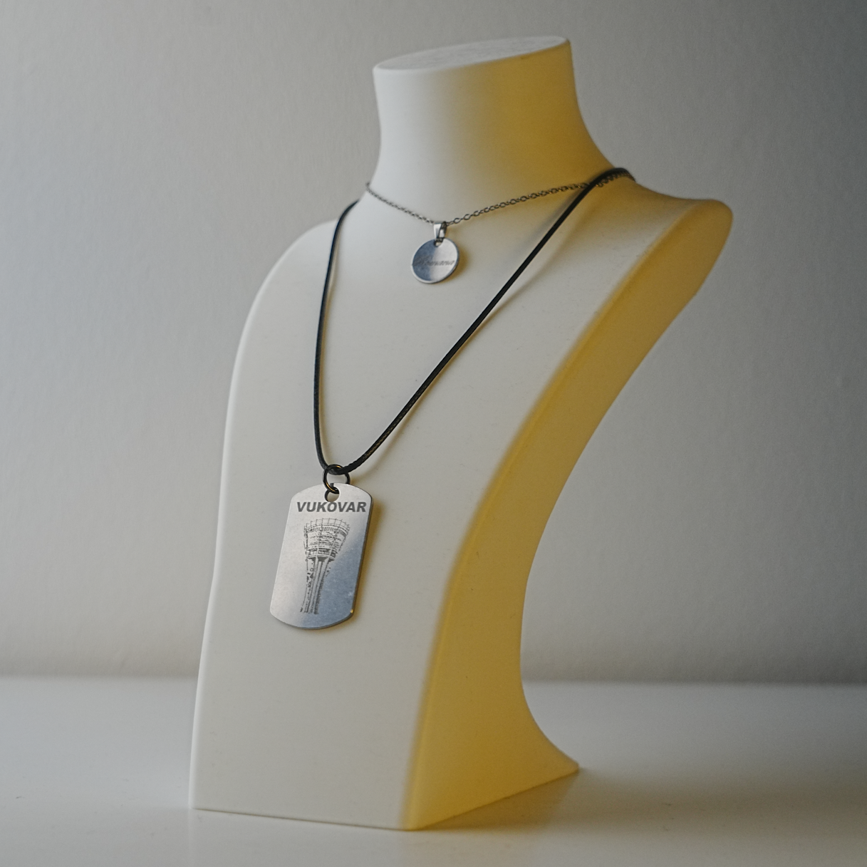 Mannequin bust with necklaces on a plain background